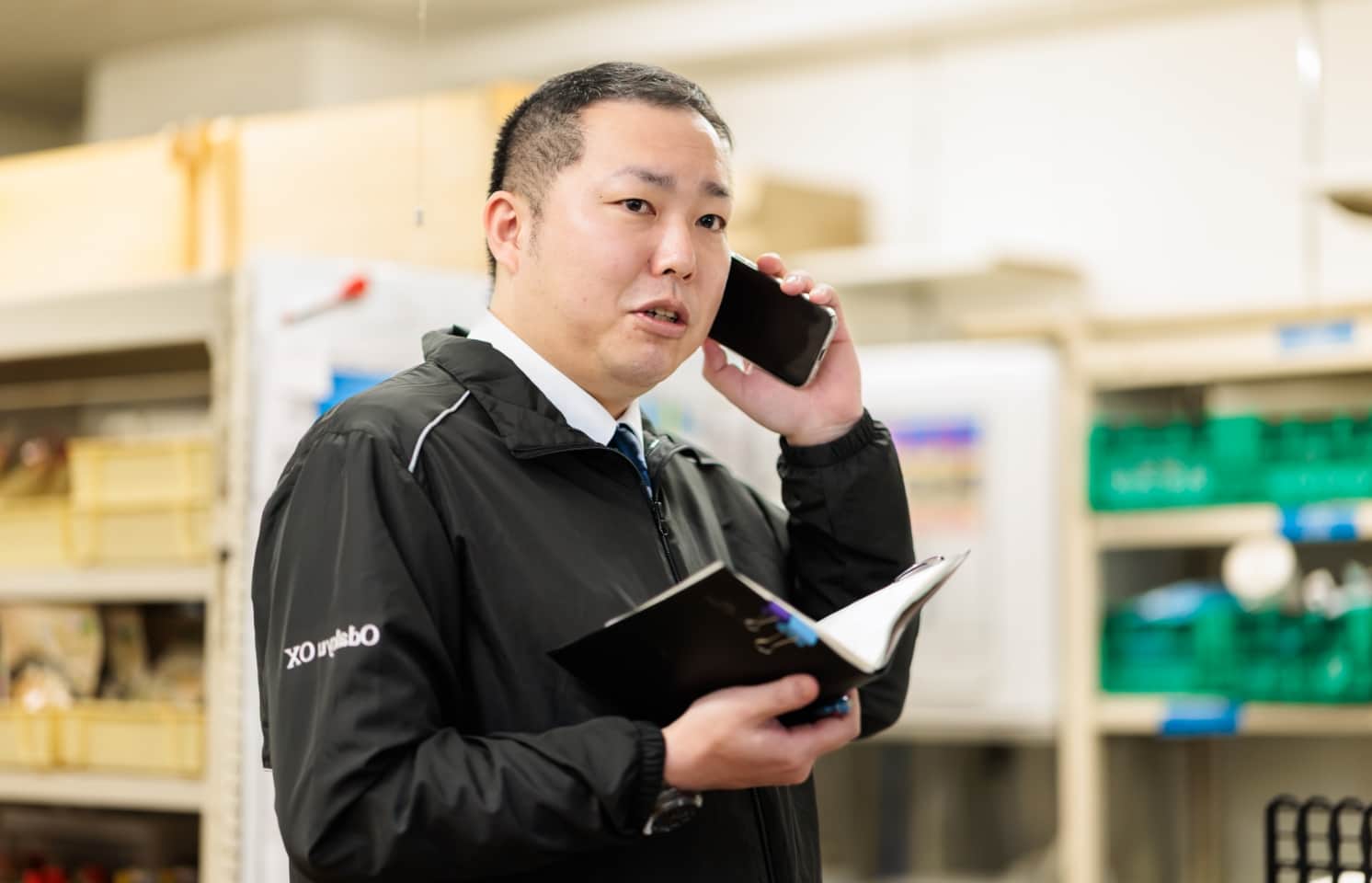 携帯で電話をする海老根　匠さん
